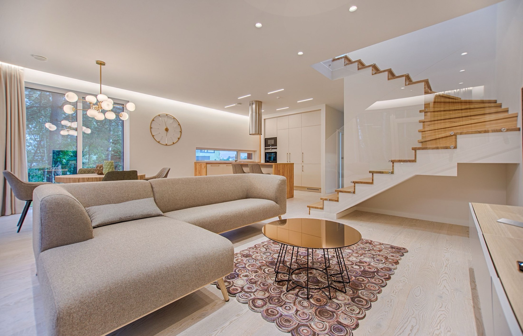 A light, open-plan living space with layered natural textures, warm timber and considered lighting